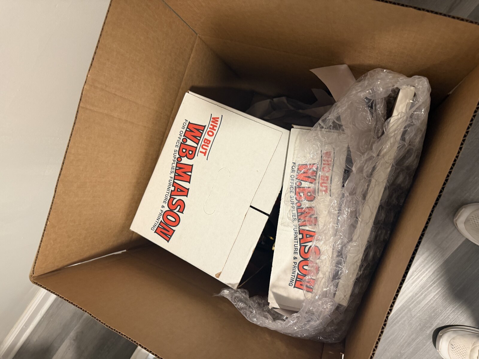 Two small office-supply boxes set inside a larger moving box