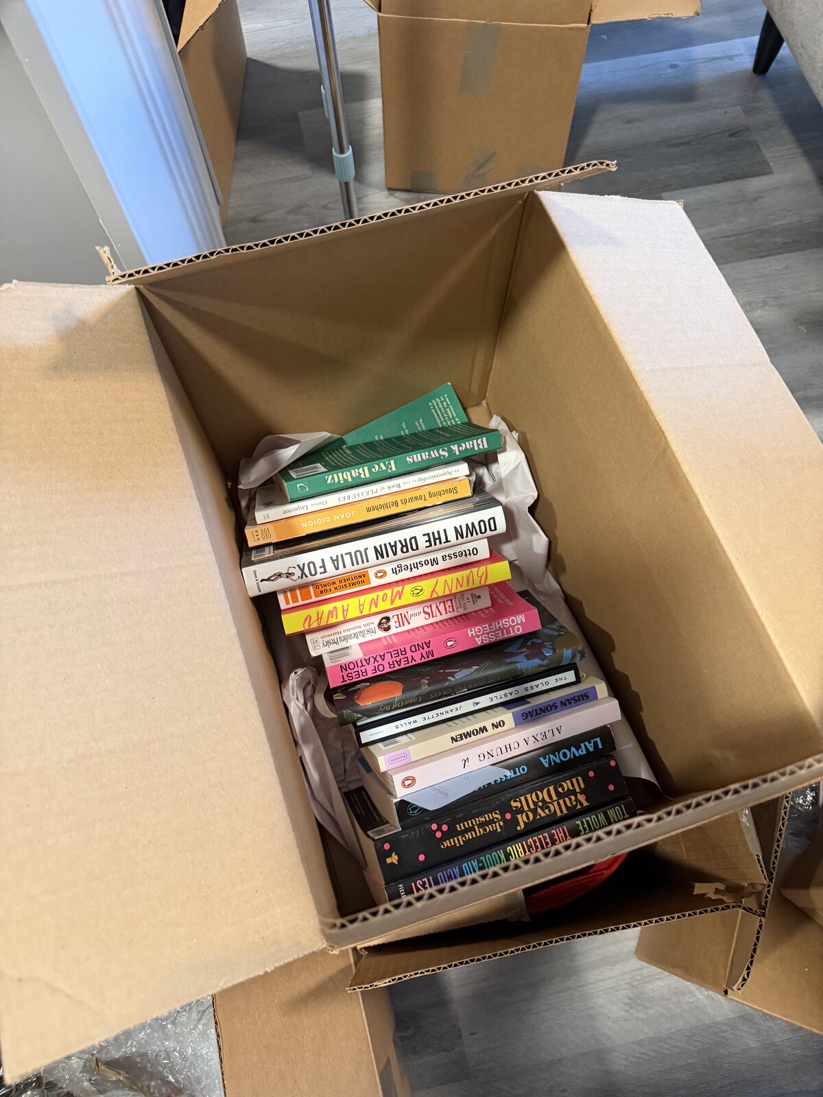 Paperback books in a small moving box