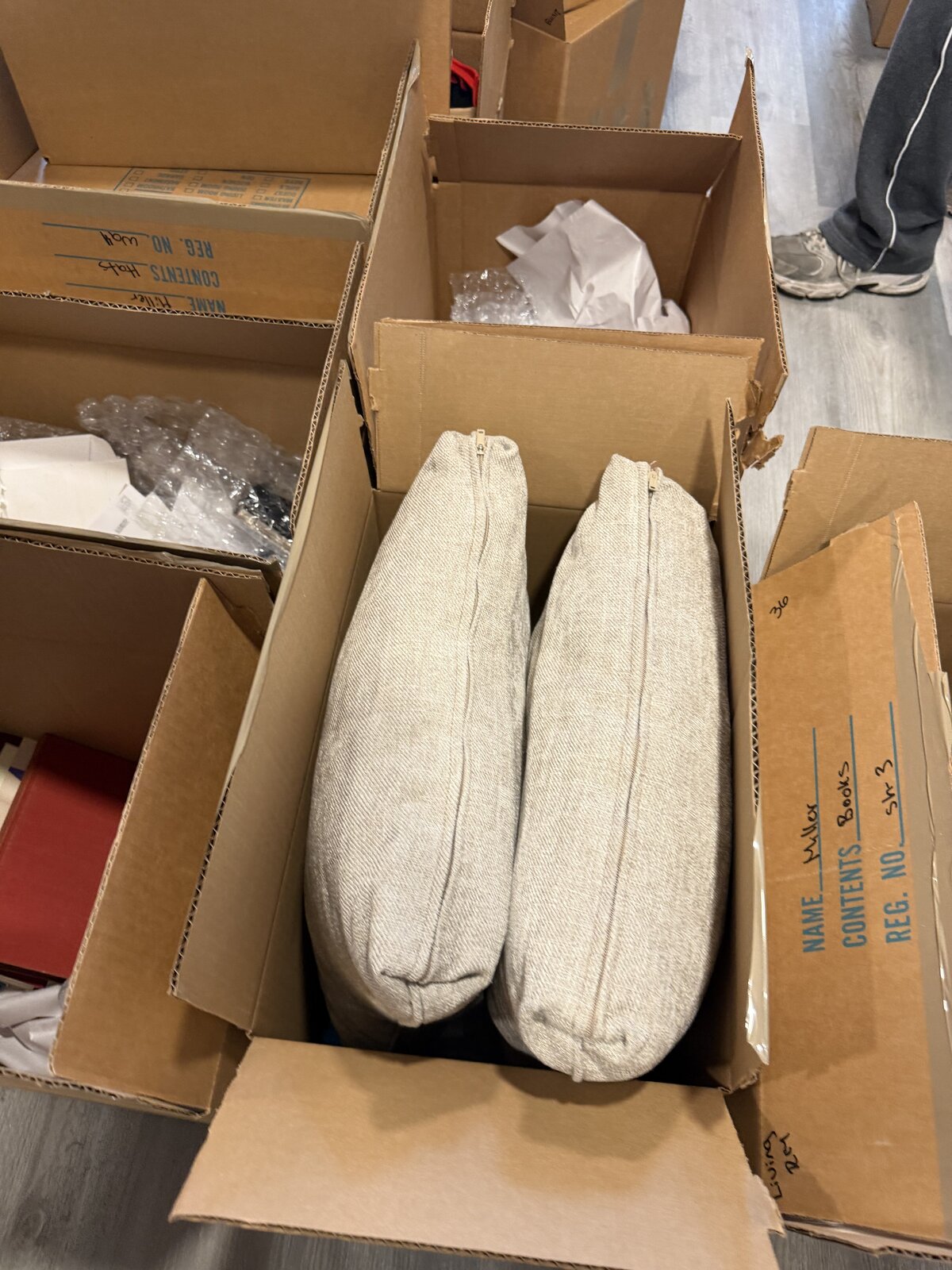 Two throw-pillow cushions filling a small box