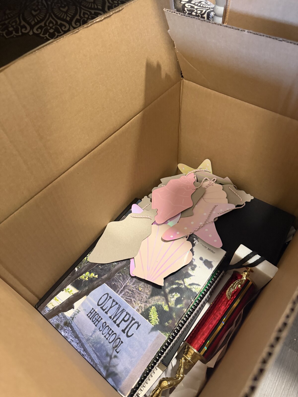 A yearbook and a few graduation keepsakes loosely packed in a small box