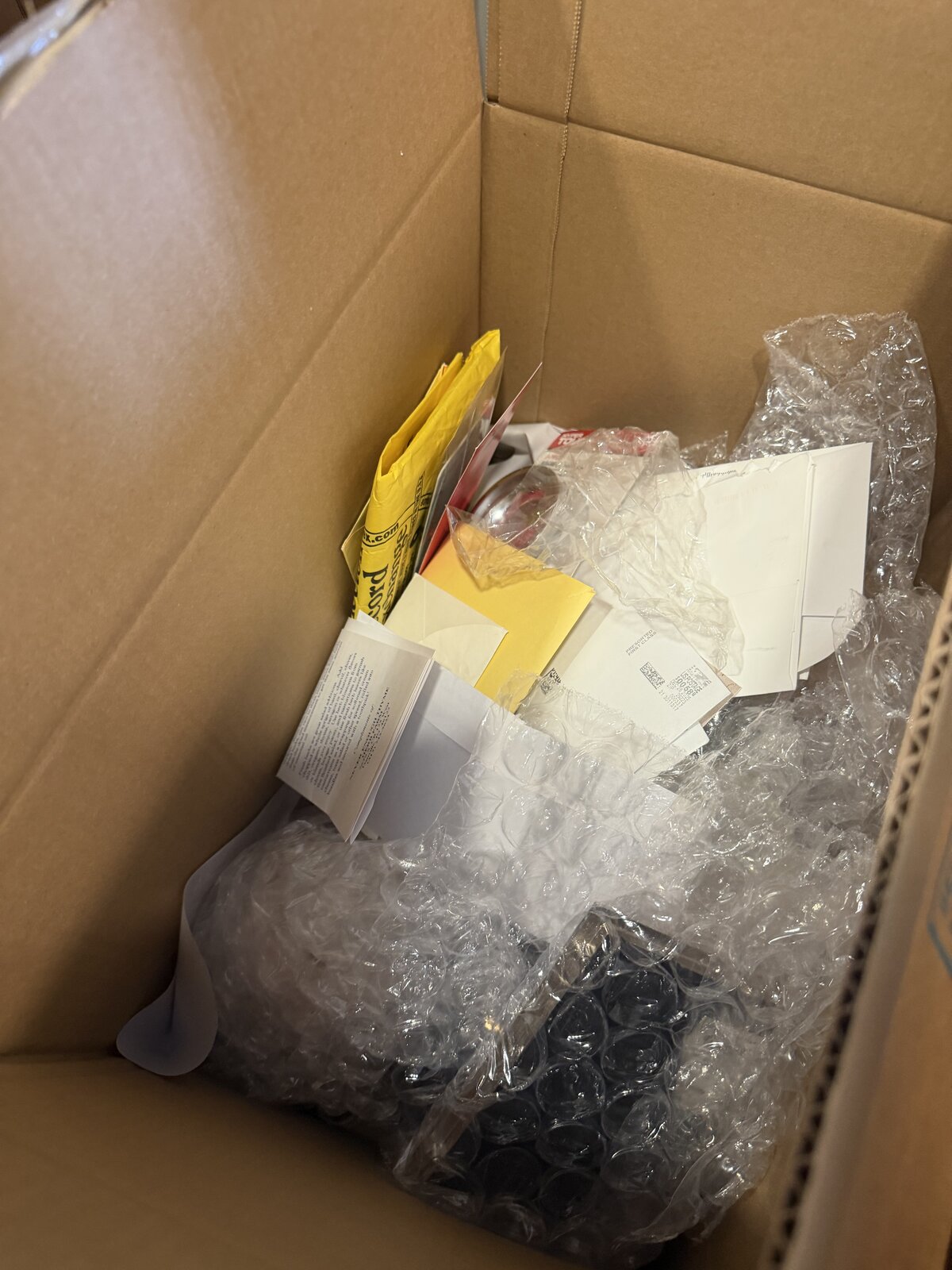 A passport envelope and loose documents packed loosely among bubble wrap