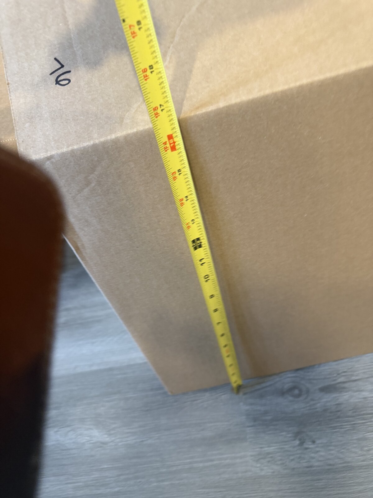 A tape measure showing a box is about 16 inches deep