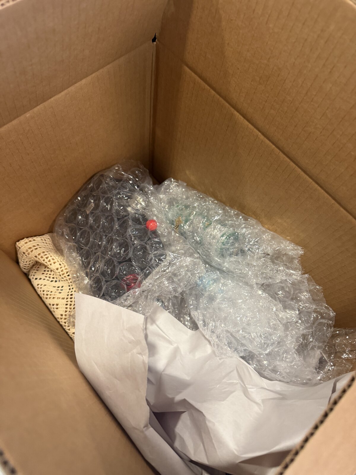 Bubble-wrapped odds and ends at the bottom of a small box